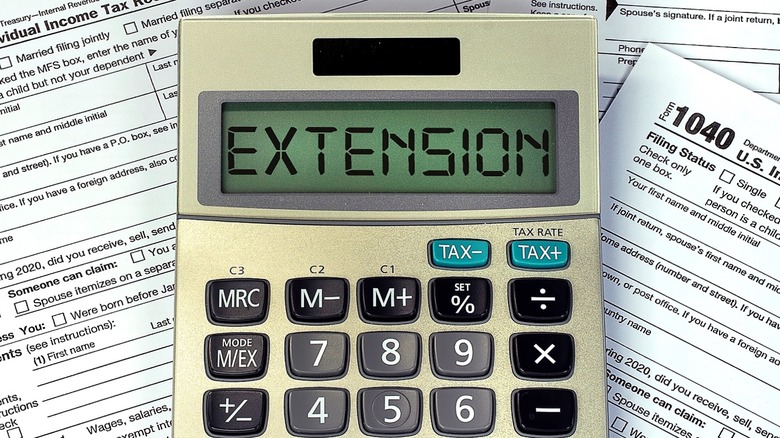 Calculator displaying EXTENSION, tax forms