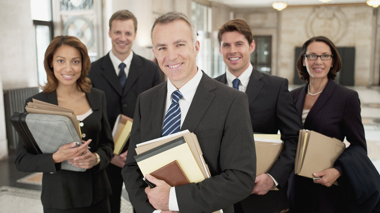 A team of lawyers each holding some files in their hands