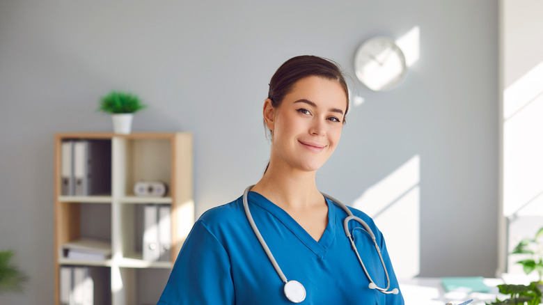 Portrait of happy female nurse or doctor at work.