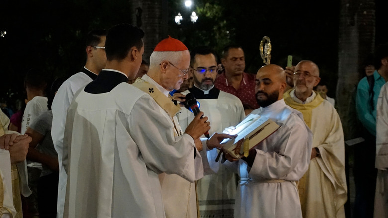 Members of the clergy and believers holding candles attend the Easter Vigil mass