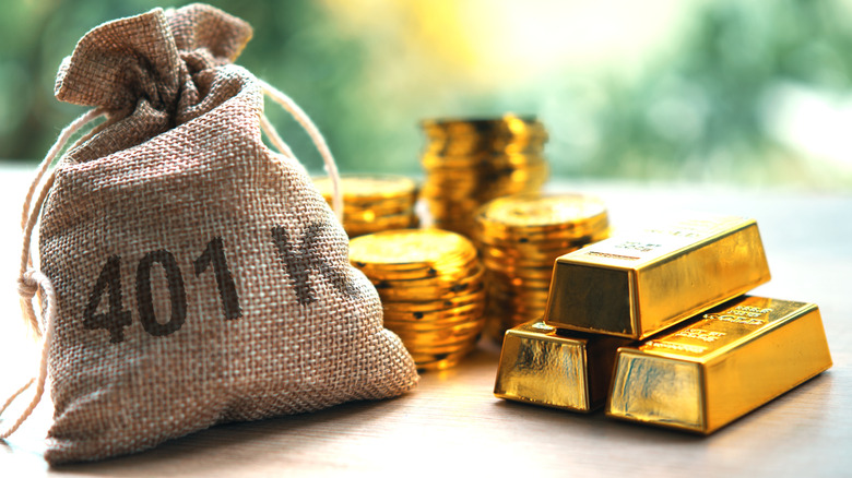 A burlap sack with '401 K' printed on it sitting next to stacks of gold-colored coins and three gold-colored bars.