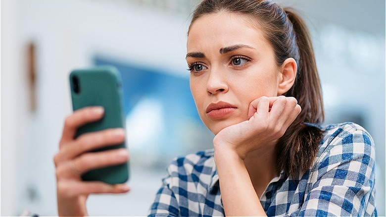 Person looking upset at phone