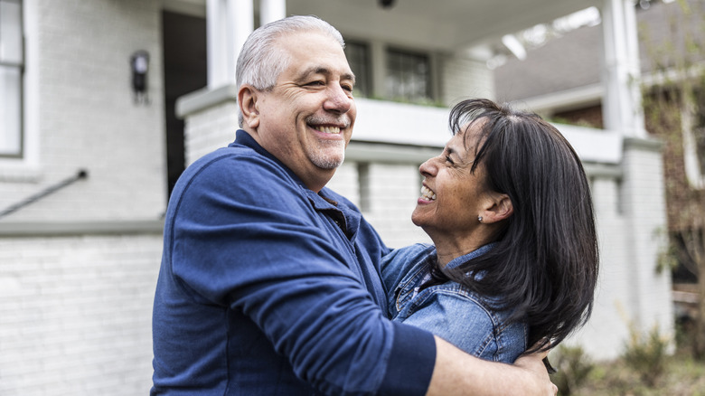 Senior couple in front of suburban home