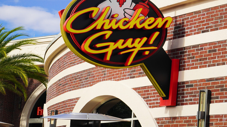 Disney World's Chicken Guy quick service restaurant sign, against a blue, sunny sky.