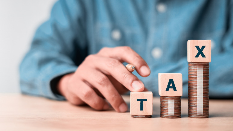 Tax spelled out on top of piles of coins