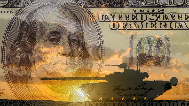 $100 bill superimposed over a tank and sunset