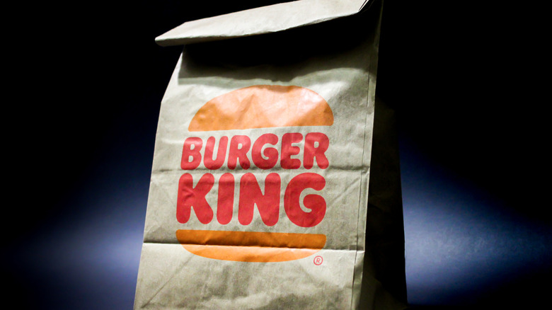 A brown to-go Burger King bag against a dark background.