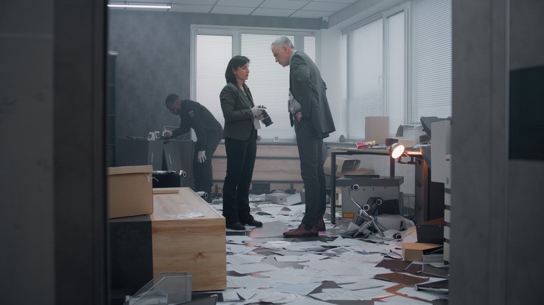 A male and female detective investigating a crime scene