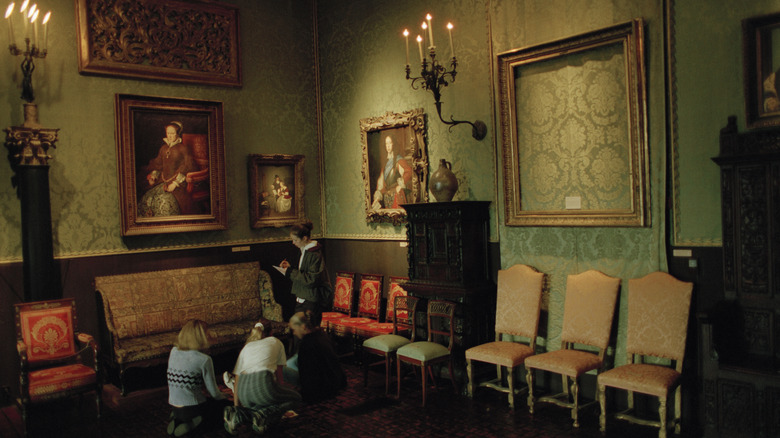 Four young girls in an art gallery with a missing artwork on the wall