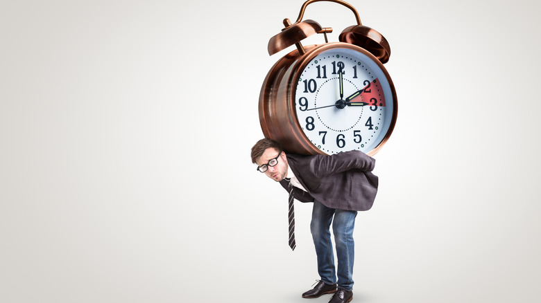 man holding a clock on his back