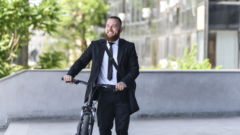 A smiling businessman with a bike