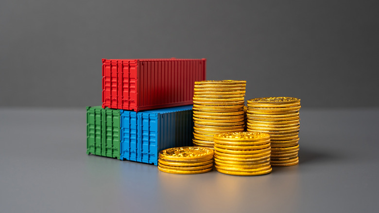 Trade containers beside a stack of coins