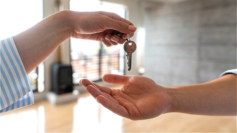 Person handing over key to home