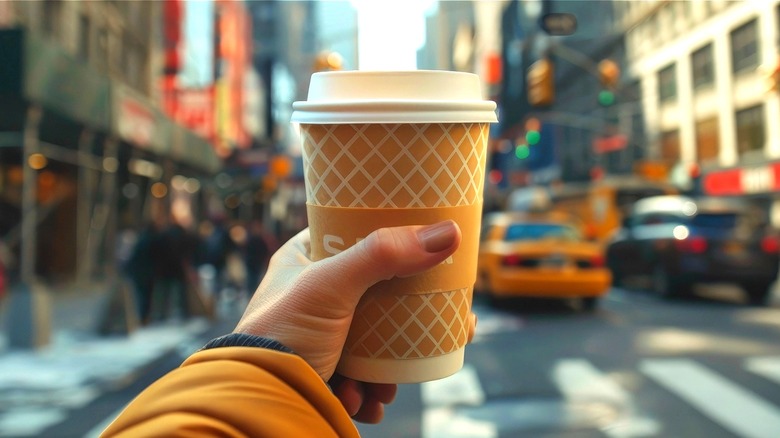 Person holding coffee to-go cup