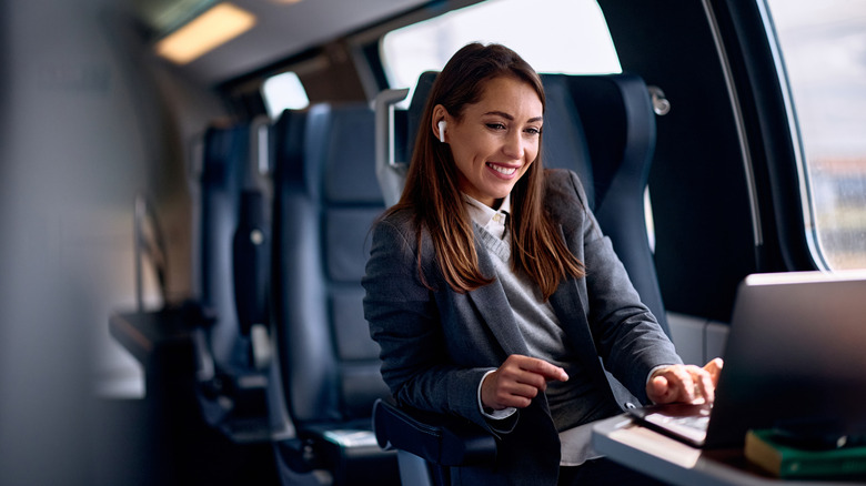 Happy businesswoman working inside a train car
