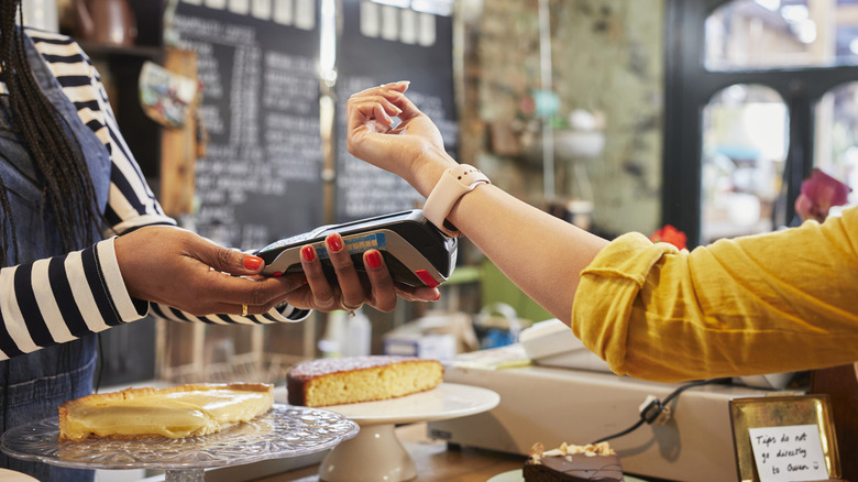 a person paying for goods with their smart watch