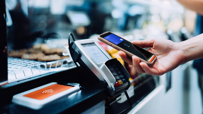 a person paying with their smartphone in a café