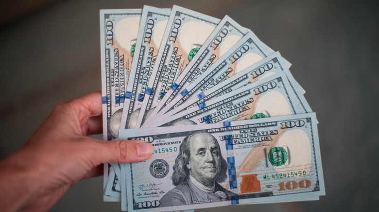 Woman holding hundred dollar bills