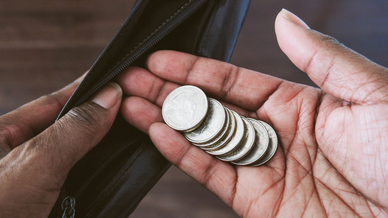 Person putting quarters inside a pouch