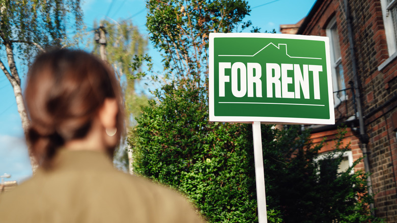 Person looking at a for rent sign