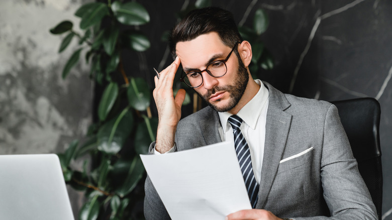 Stressed out business man checking over financial statement