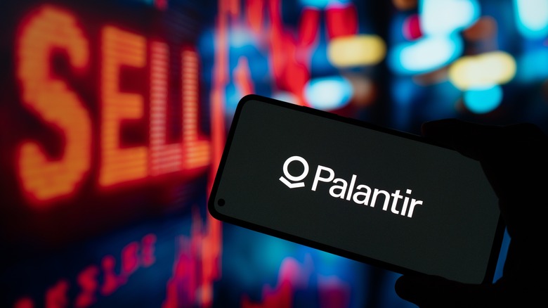 Palantir logo on smart phone screen over sell sign