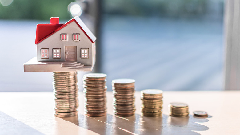 toy house with rising stacks of coins