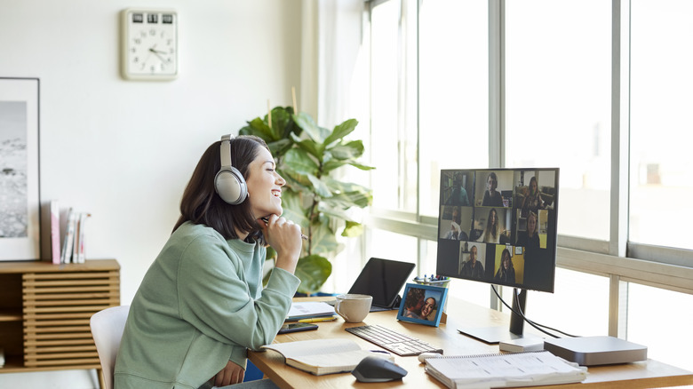 A smilimg woman sitting in front of monitor during a video conference