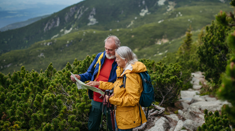 An elderly man and woman looking at a map on mountain