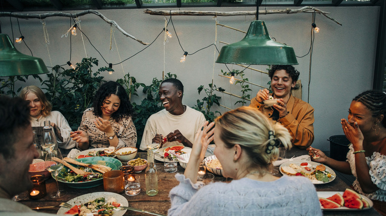 A group of friends sitting around a dinner table and having a great time