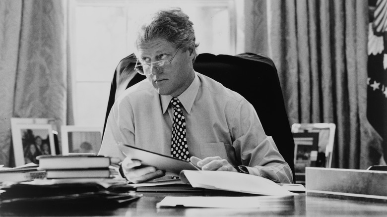 Bill Clinton looks over glasses