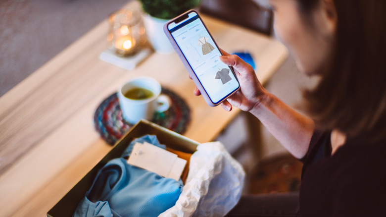 Young woman doing online shopping for clothes  at home