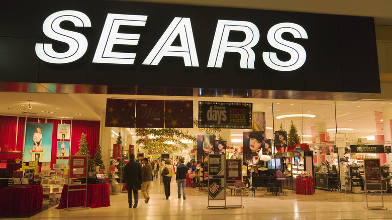 An establishing shot of Sears shop with people going in i.