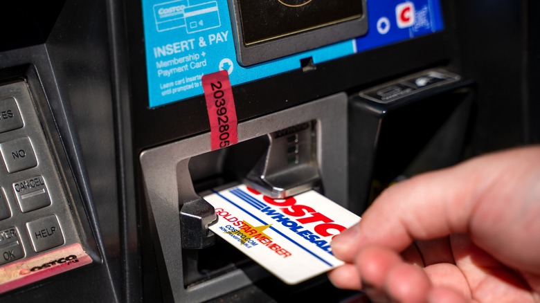 A man inserting his Costco Wholesale card into debit machine