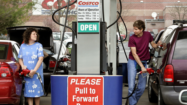 Two women pumping gas into their vehicles at a Costco gas station