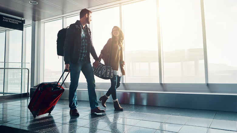 Couple in airport together for overseas trip or vacation