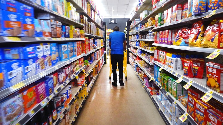 The back of a shopper walking down the snack aisle at a Dollar General