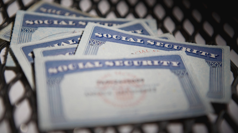 Six Social Security cards lying on a table with the details blurred.