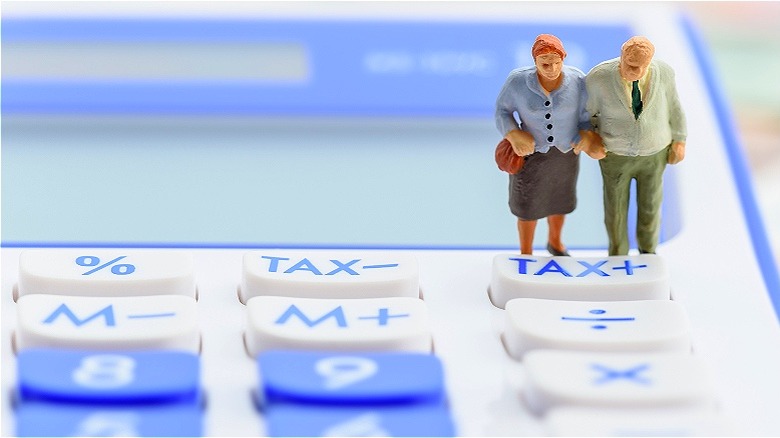 Figures standing on tax calculator