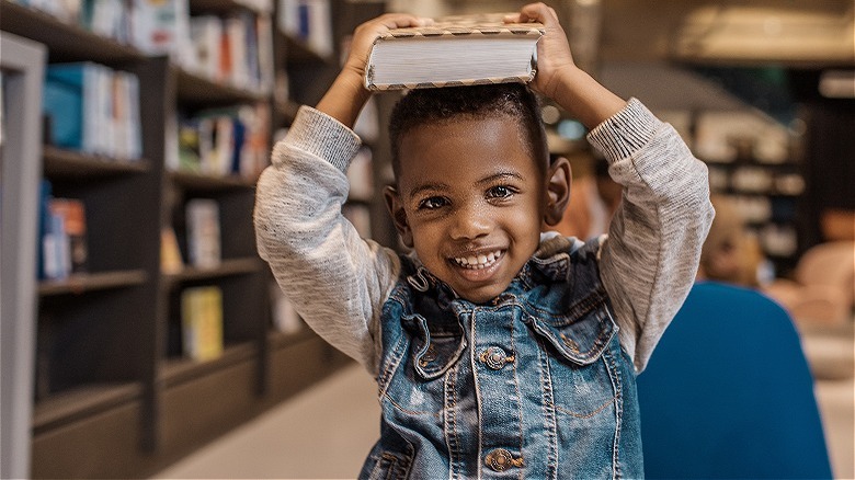 Boy holding book in library