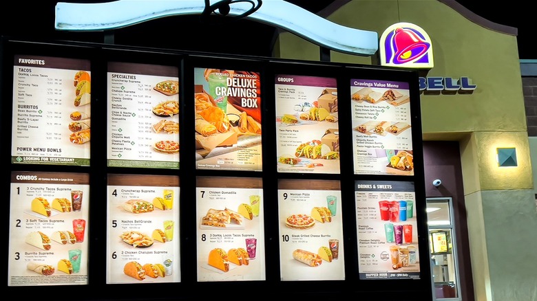 Illuminated Taco Bell menu outside the front entrance of a Taco Bell at night