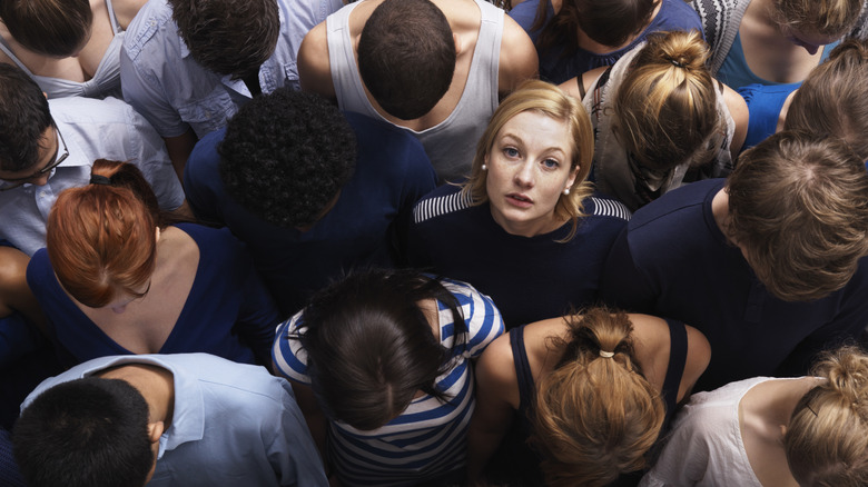 An aerial view of a group of people looking down with one woman looking up/