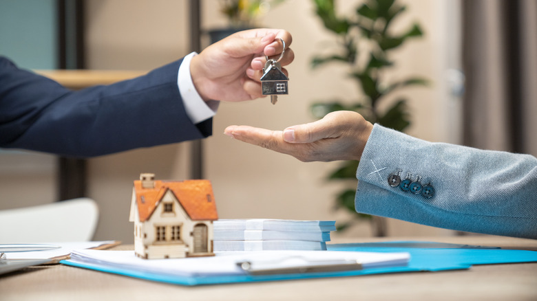 Real estate agent handing woman keys to home