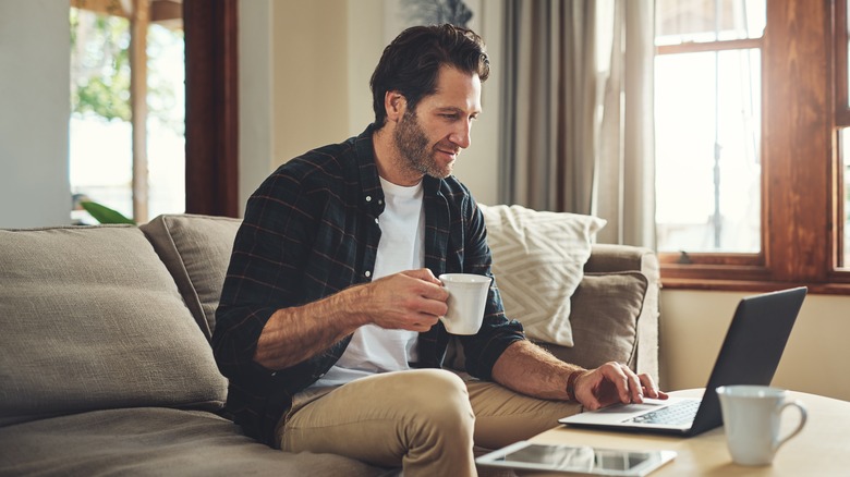 A man sitting on his couch working from home