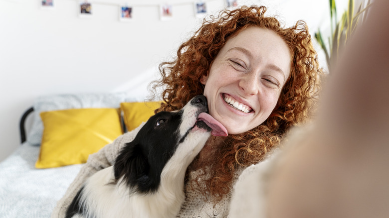 A woman in her bedroom with her dog who takes care of her