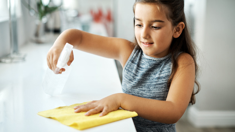 a child cleaning a countertop