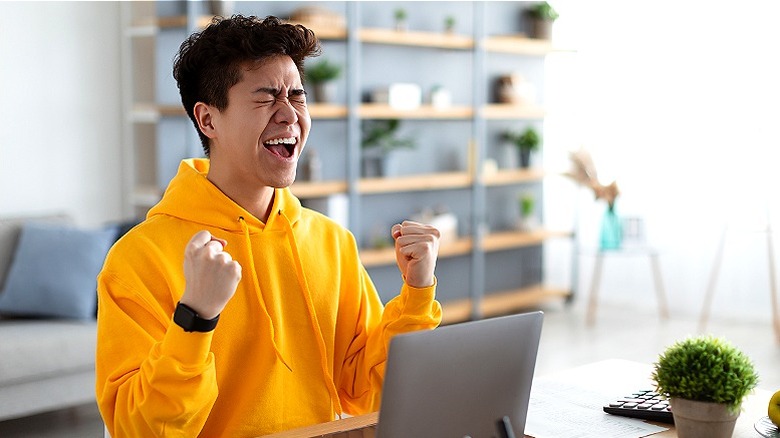 Person exclaiming joy at computer