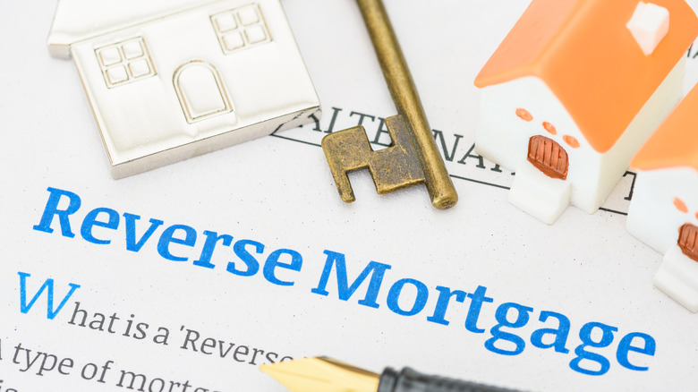 Reverse mortgage defined with key, pen, and concept house