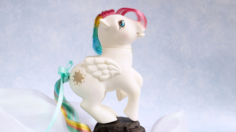 A G1 Starshine vintage My Little Pony pegasus toy, posed on a rock against a white background.