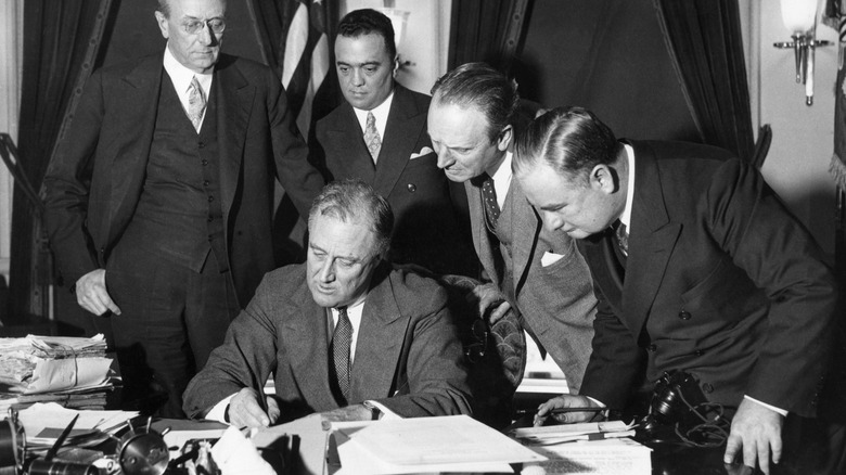 FDR signs bill while men watch